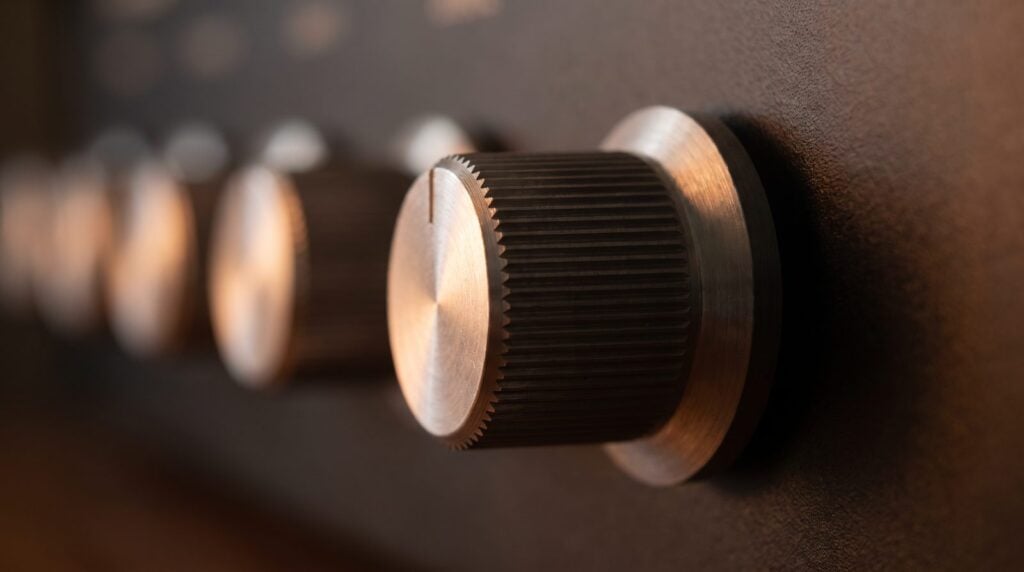 Close-up of a stepped metal knob on a hardware mastering EQ, a reminder that mastering moves are small