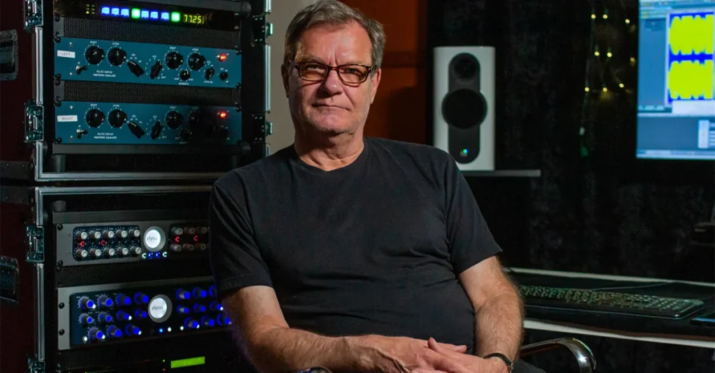 Mastering engineer John Greenham in his studio in front of racks of hardware, from Mix With The Masters