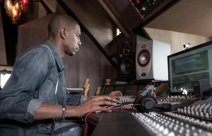 An engineer at a large studio mixing console, the cover image of Young Guru's mixing class on Skillshare