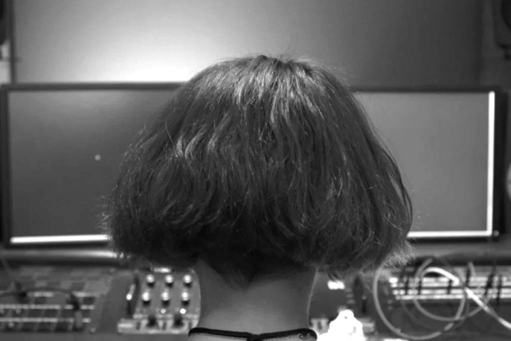 Black and white image of a producer facing a studio desk, from Berklee's music production classes on Coursera