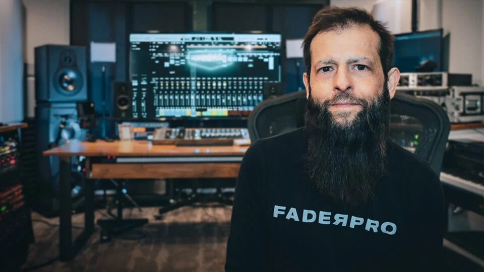 FaderPro image for The One Hour Mixing Workflow: a producer in a FaderPro shirt in a studio with a large mixing screen