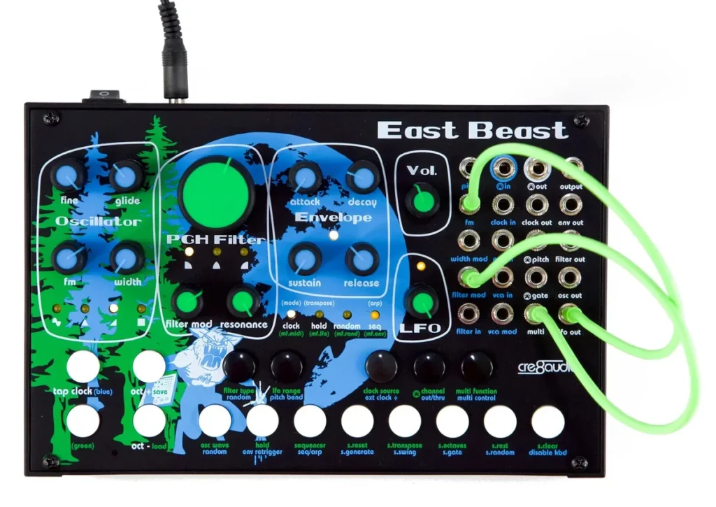 Cre8audio East Beast semi-modular synth with a blue forest-print panel, a big green filter knob and green patch cables